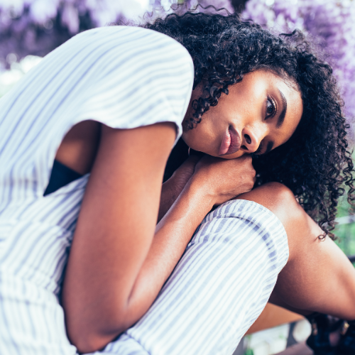 women bent over, looking contemplative.