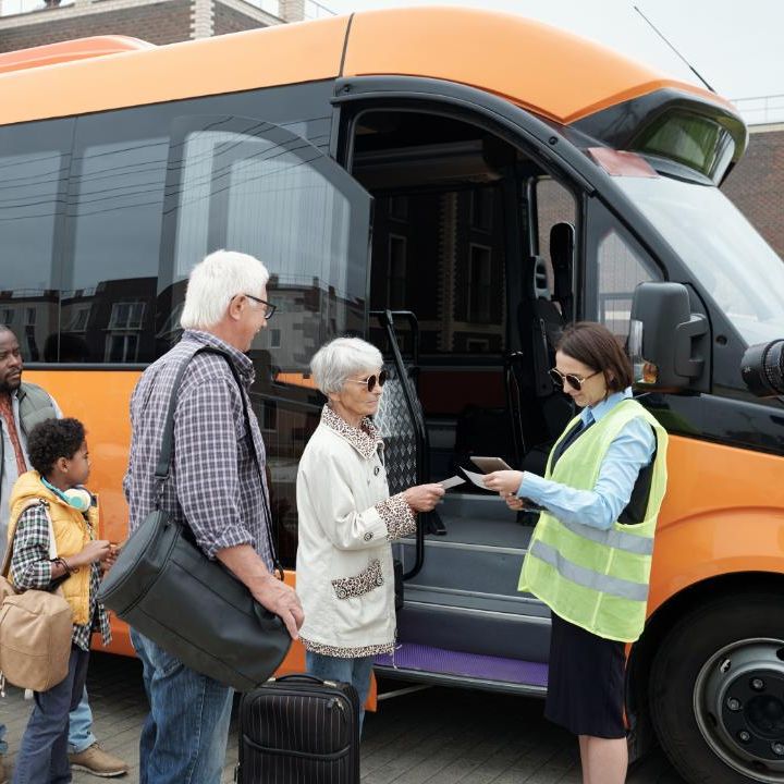Older folks being welcomed onto a small buss