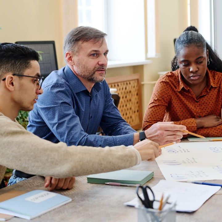 Three people at a conference table planning