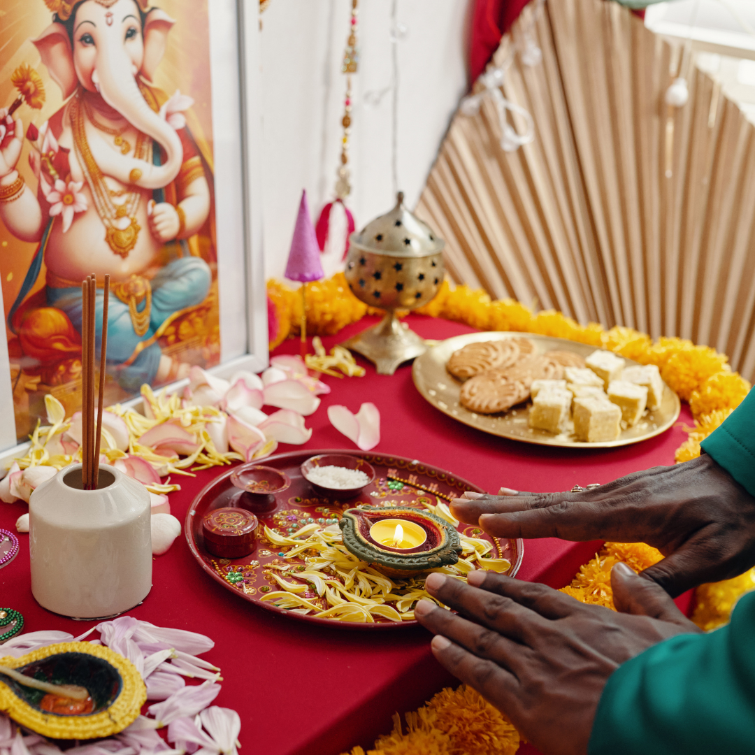 Man with hand on offering tray, Indian god Ganesh shown 