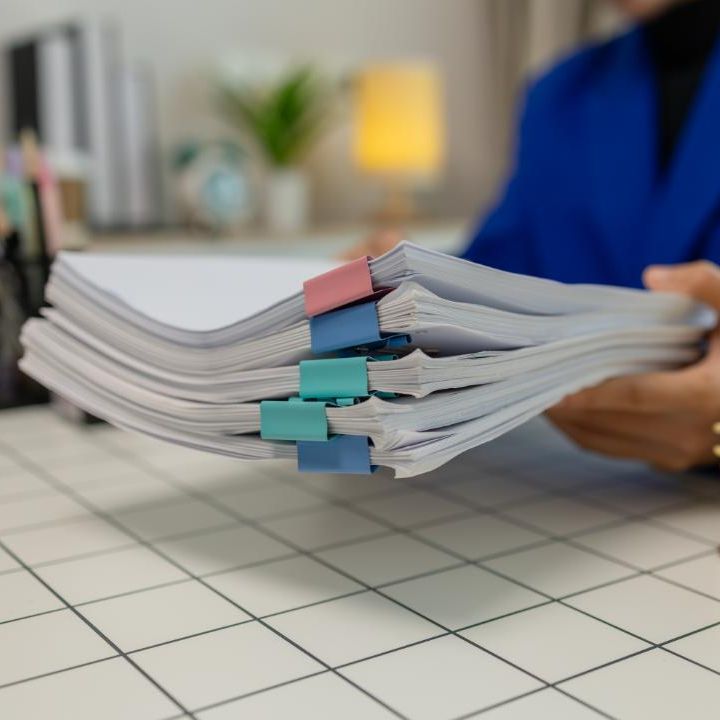 Close up of stacks of papers with binder clips, being held my someone