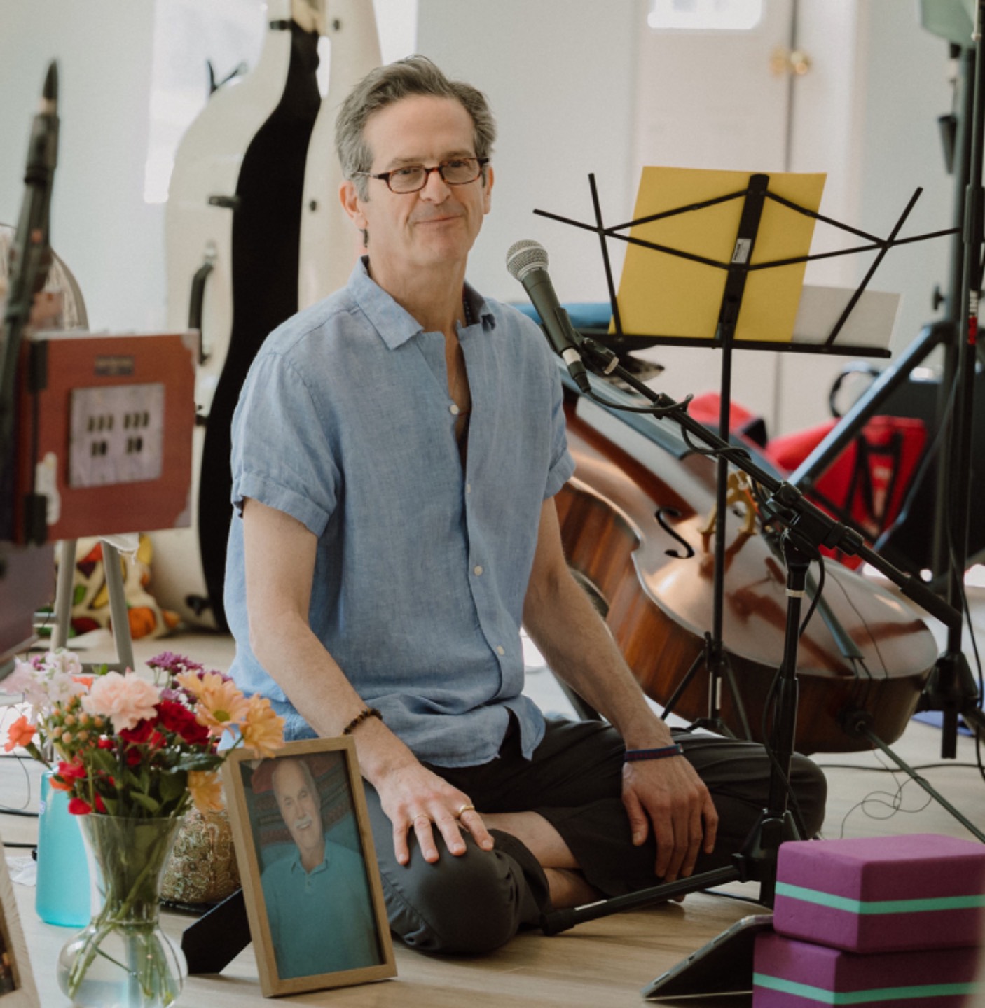 Noah Hoffeld seated with his cello, leading a meditation class
