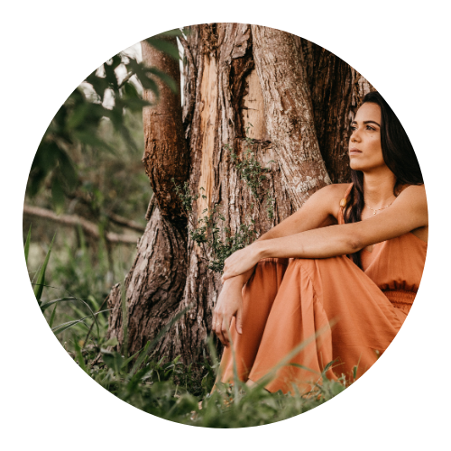 woman sitting by tree, looking into the distance