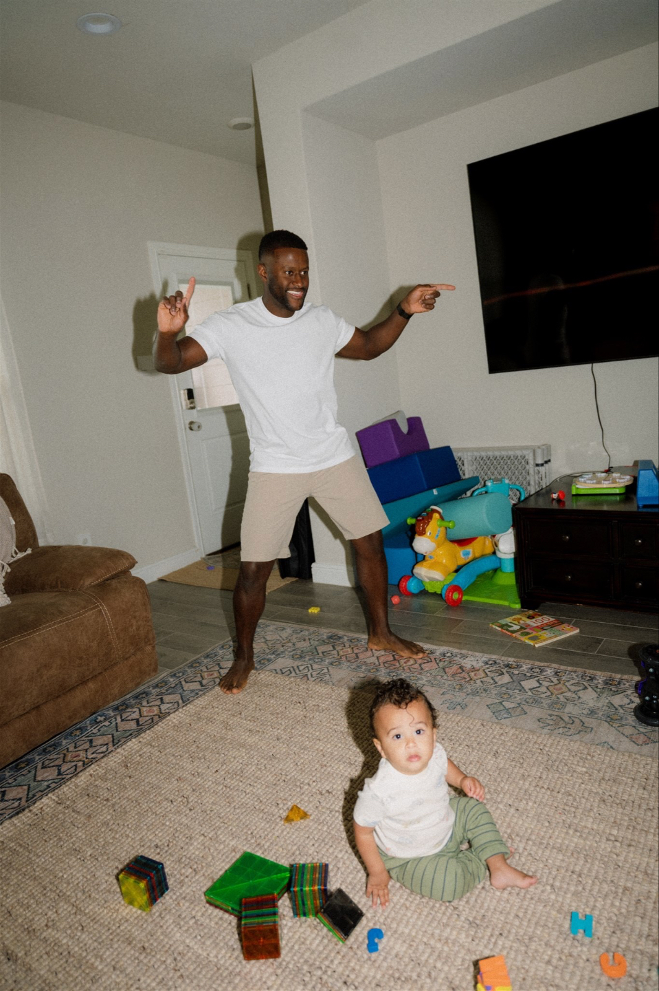 Joyful parent plays with their baby at home beneath the words "Clarity. Confidence. Care." - capturing connection, laughter, and whole-child wellness in everyday moments.