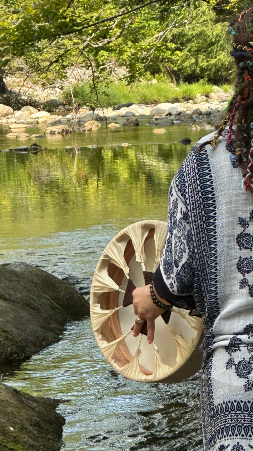 person playing a drum at the riverside