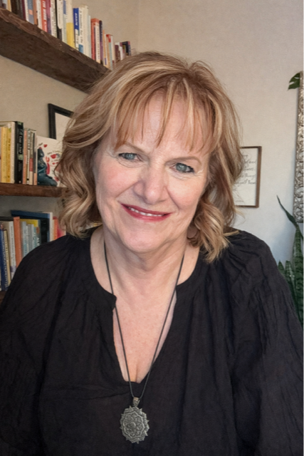 Cindy Butler smiling gently, dark background 