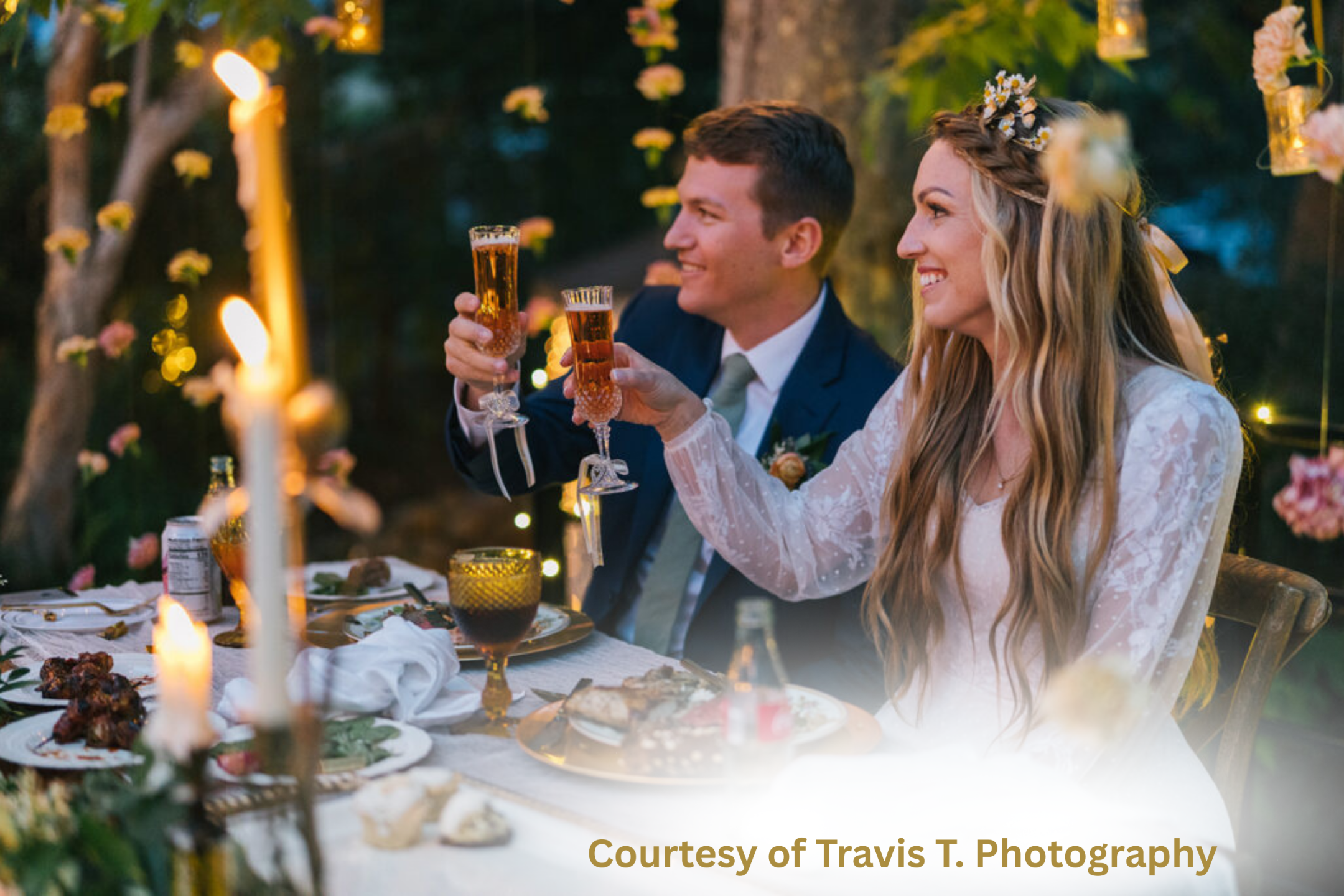 Latter-day Saint bride and groom sharing a joyful wedding toast at an outdoor reception table adorned with candles, florals, and golden glassware — symbolizing love, light, and celebration. Image courtesy of Travis T. Photography.