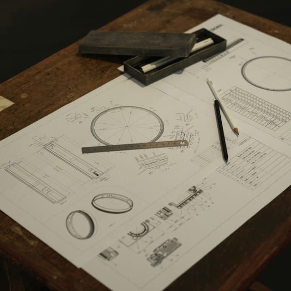 Technical blueprints on a table representing business planning and design.