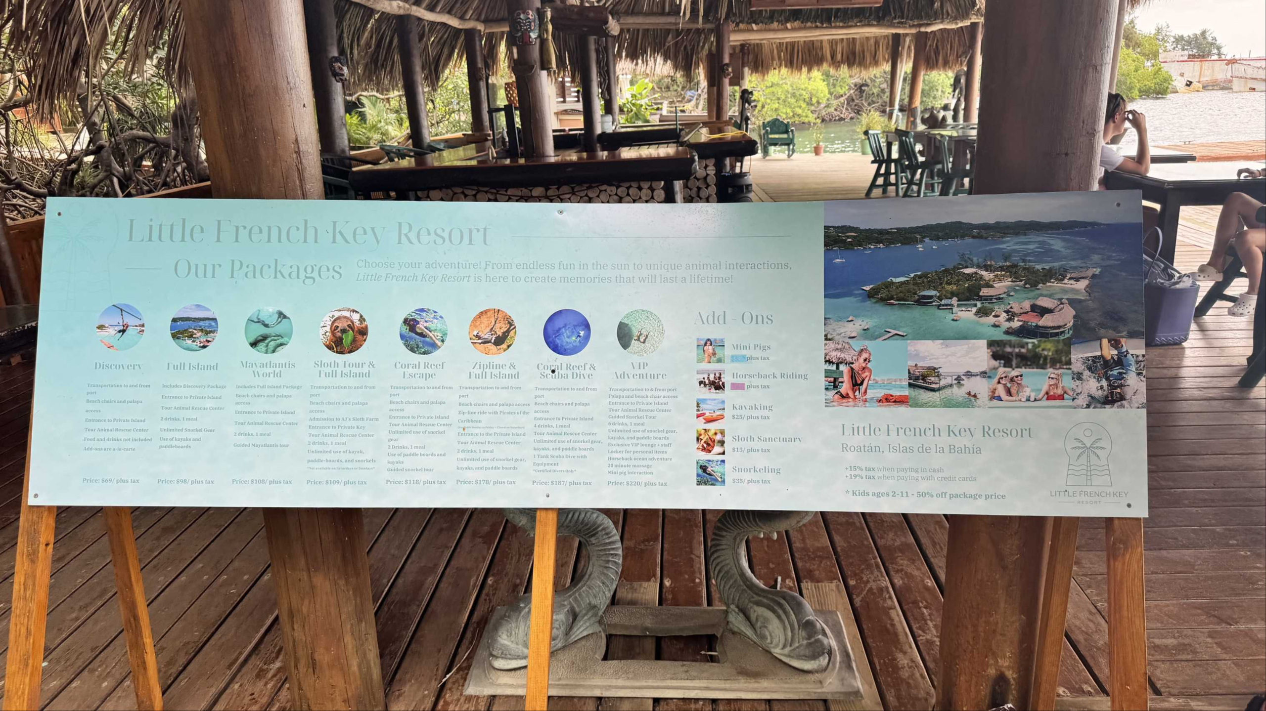 Little French Key Roatan: Professor Melissa relaxing in the clear turquoise water beneath a thatched roof.