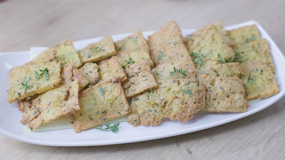 Fertige ayurvedische Panelle mit Schwarzkümmel und frischem Thymian auf weißem Teller – glutenfreies Ayurveda Rezept