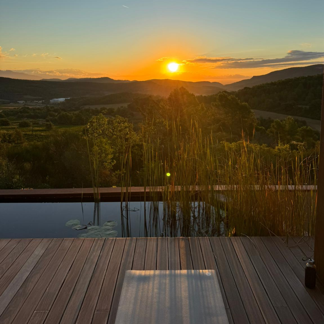 A large infinity pool with cream sun loungers and mountain views in Spain at Yourself Yoga’s menopause wellness retreat. 