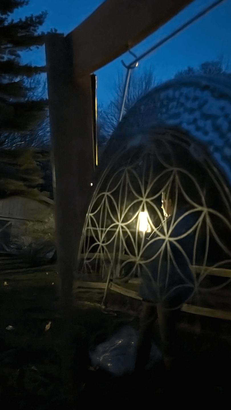Stainless steel gong reflecting a person holding a light