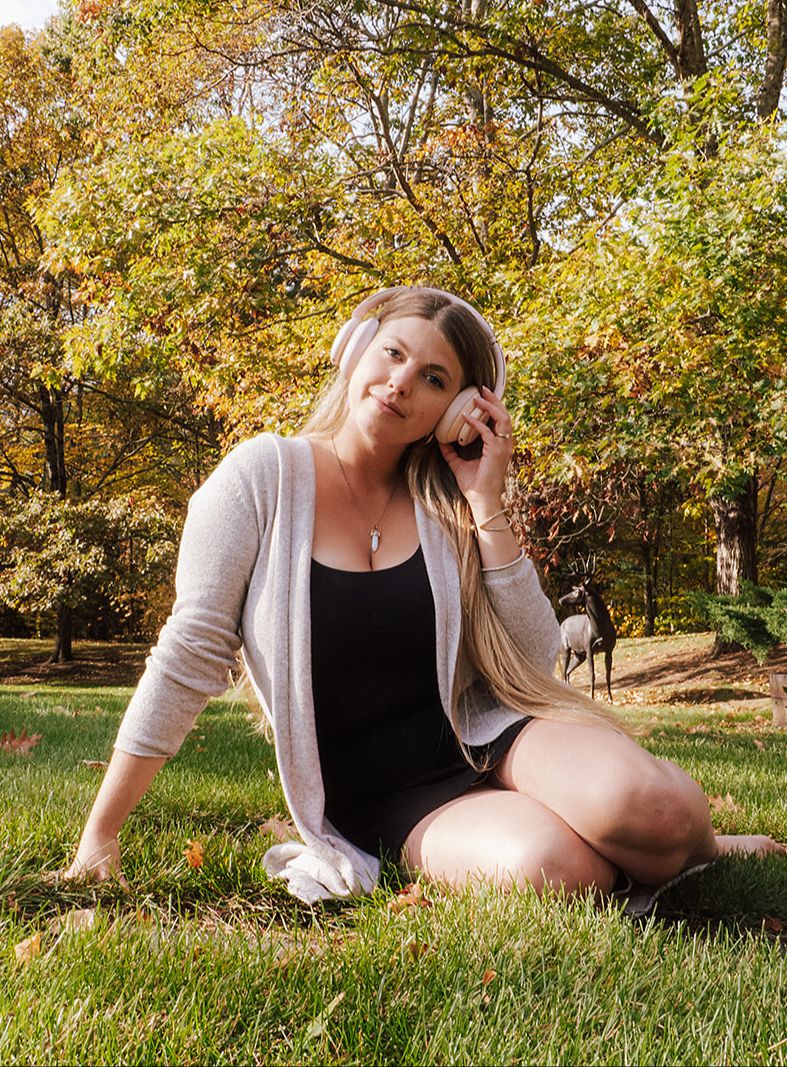woman sitting on the grass wearing headphones