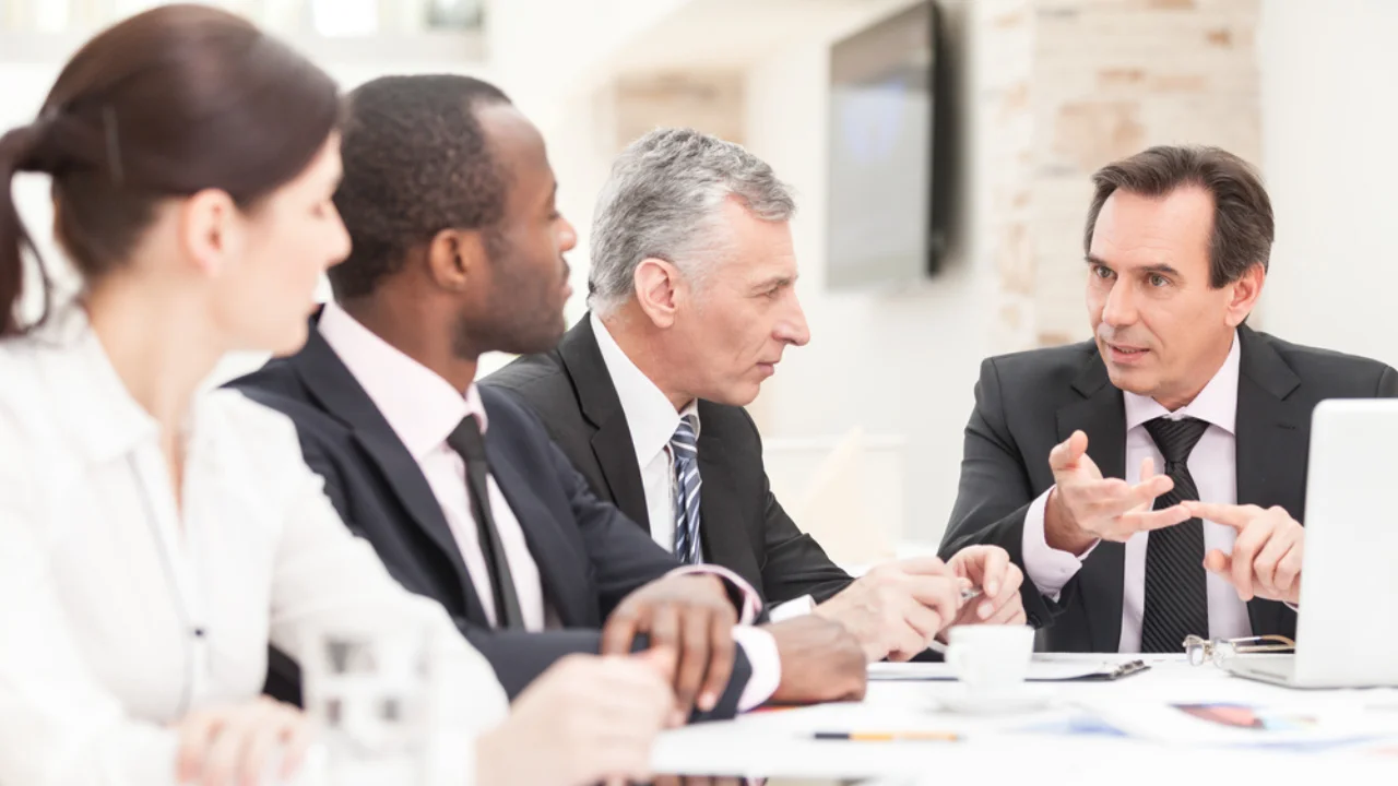 executive meeting with a group of people discussing around a table