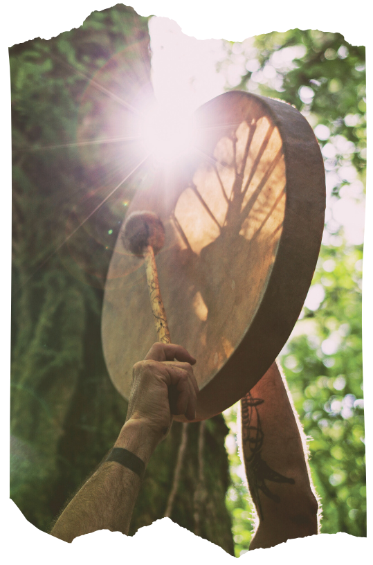 Shamanic drum held in sunlight in a forest, representing journeywork, channeling, and healing practices.