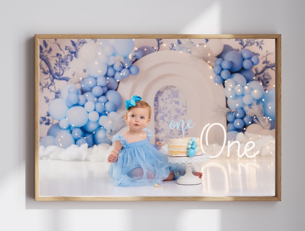 one year old girl eating birthday cake looking off to the side of camera