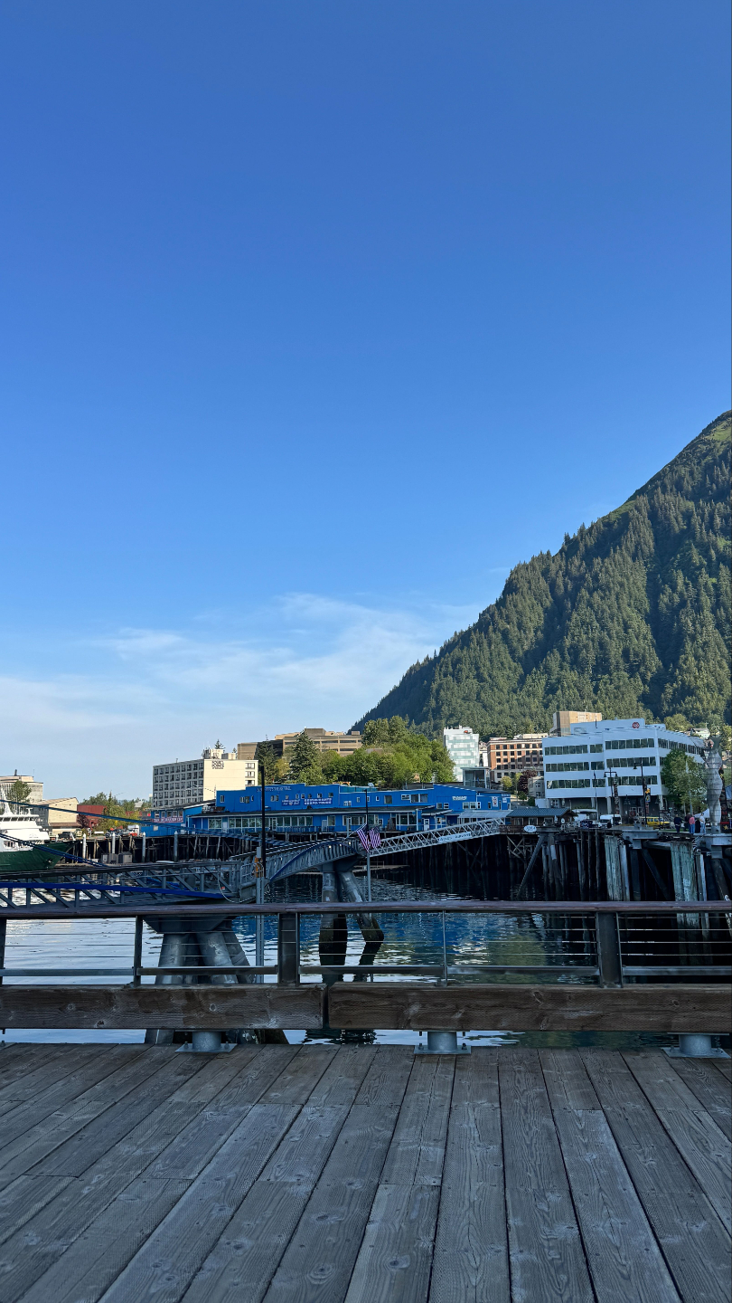 Juneau Cruise Port: Downtown boardwalk with mountain backdrop and clear blue skies.