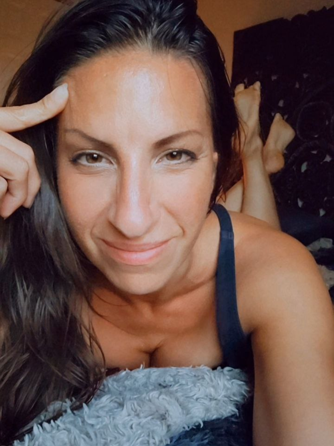 Women's embodiment coach, Emily Wehrman smiling with her feet up on a blanket.