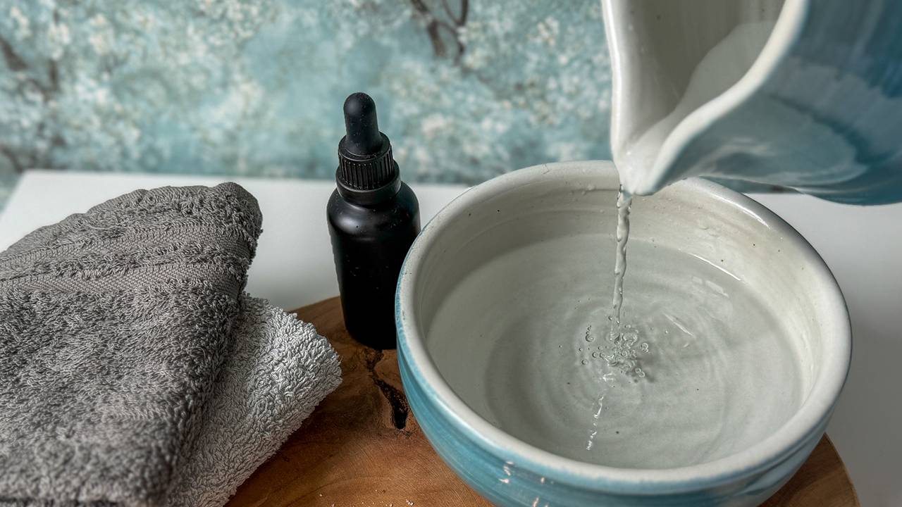 Face yoga teacher demonstrating a lifting face yoga exercise with fingers placed along the cheeks