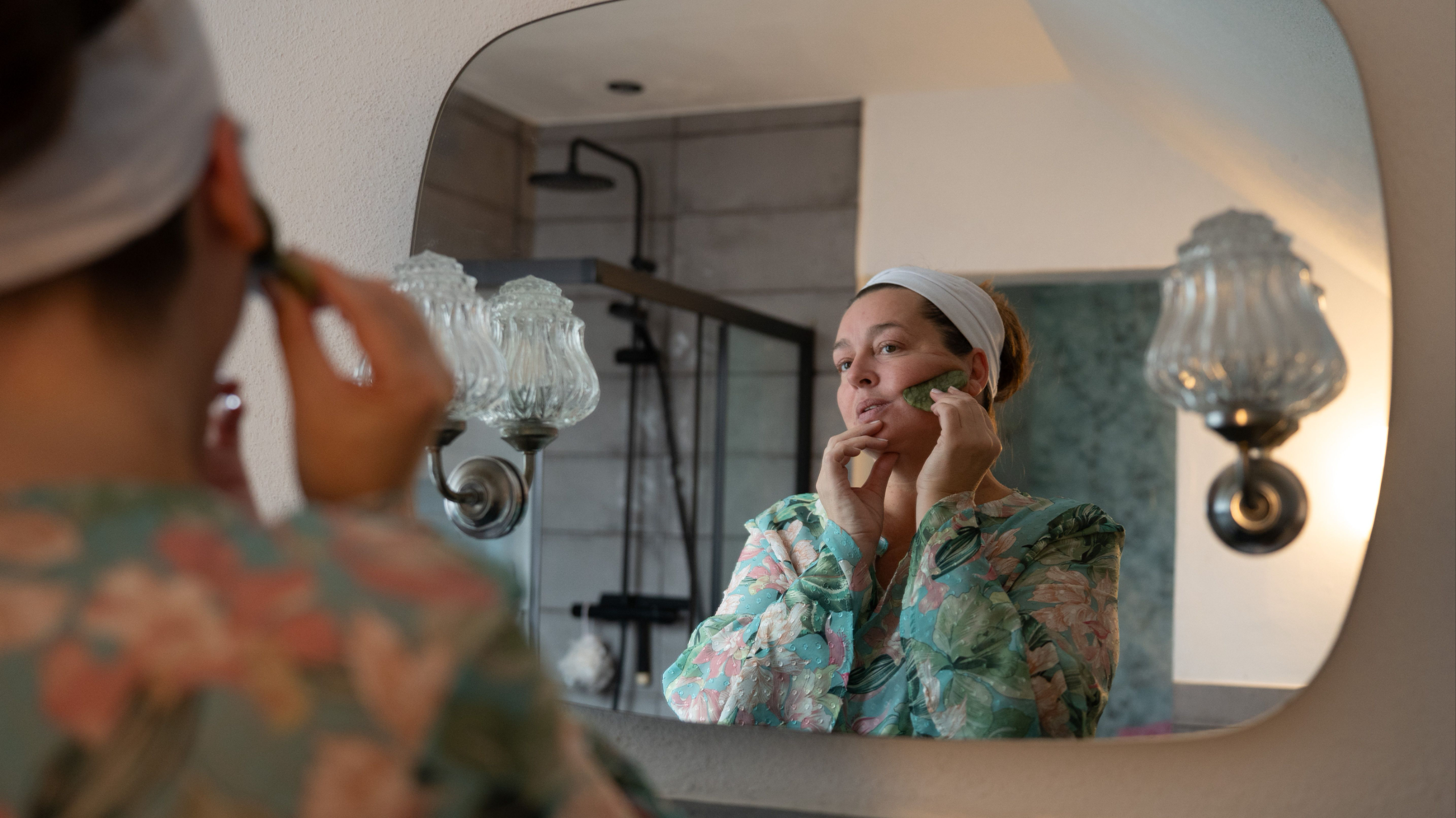 Face yoga teacher practicing a relaxing face yoga exercise with one hand resting over the eye