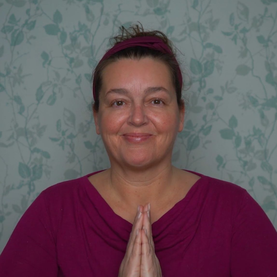Face yoga teacher looking upward with a book balanced on her head