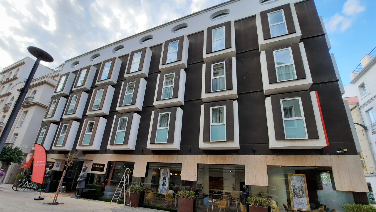 The hotel before, a bare dark facade