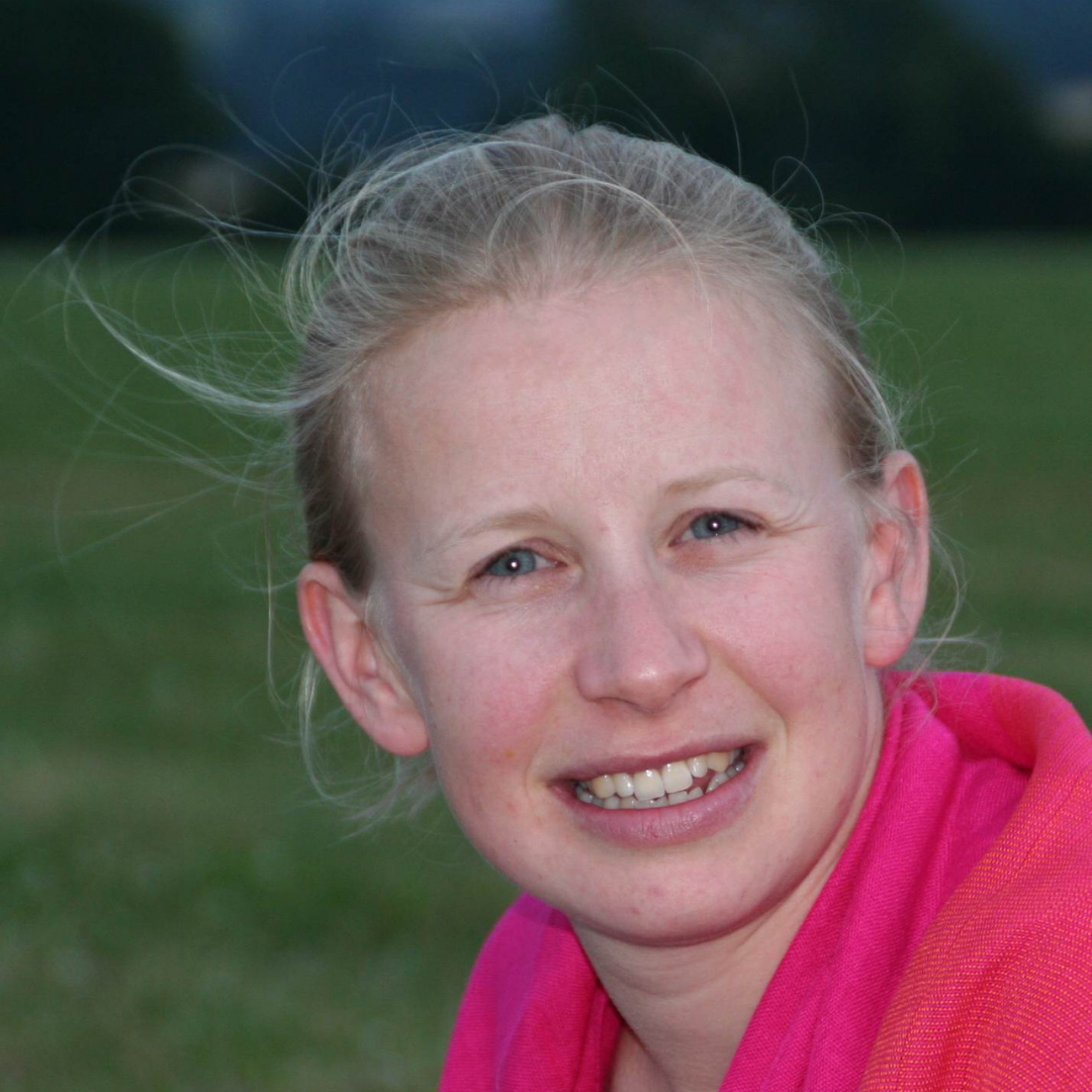 Kate Parker, a blonde smilling woman with her hair tied back and wearing a pink top