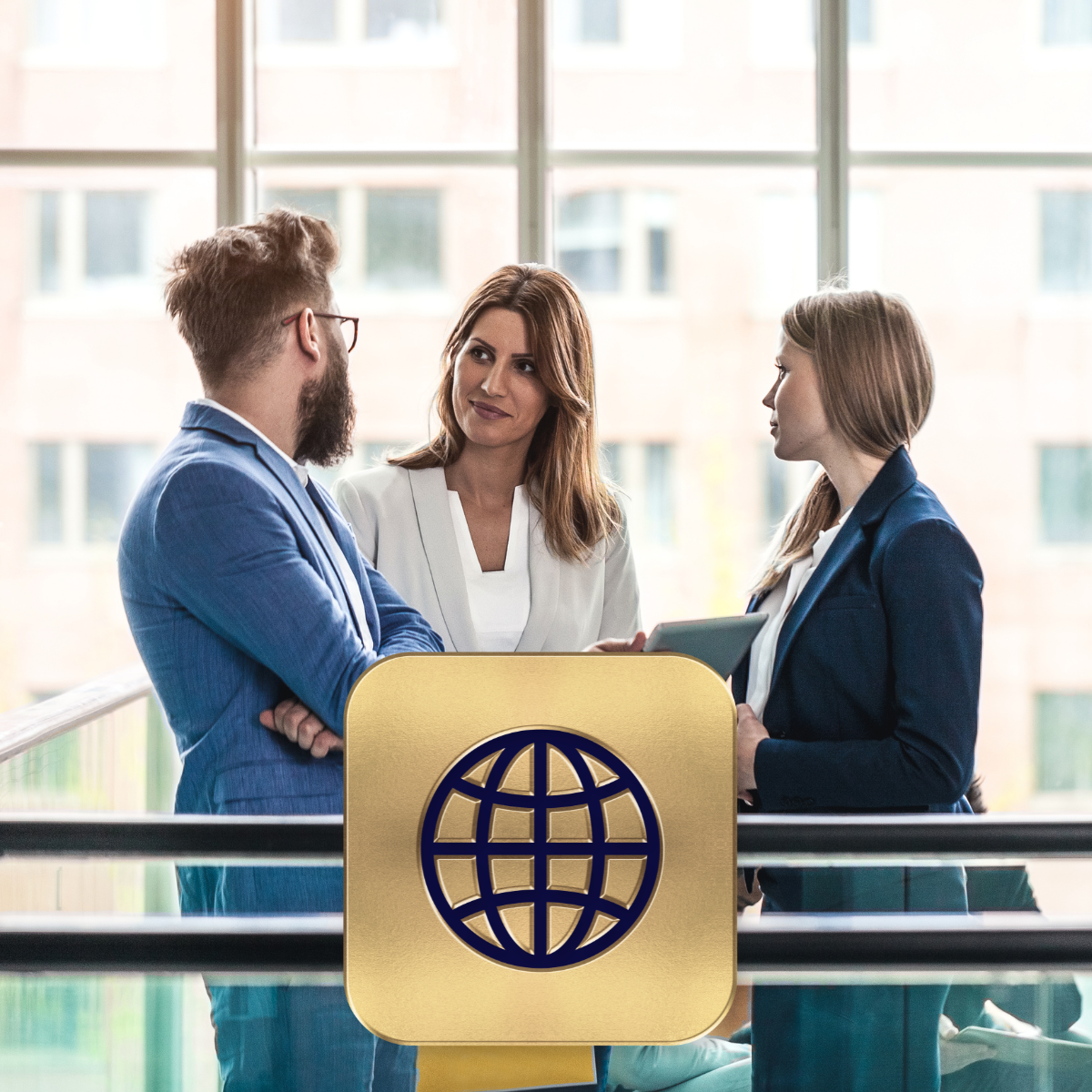 Three professionals chatting in front of a large glass window in an office