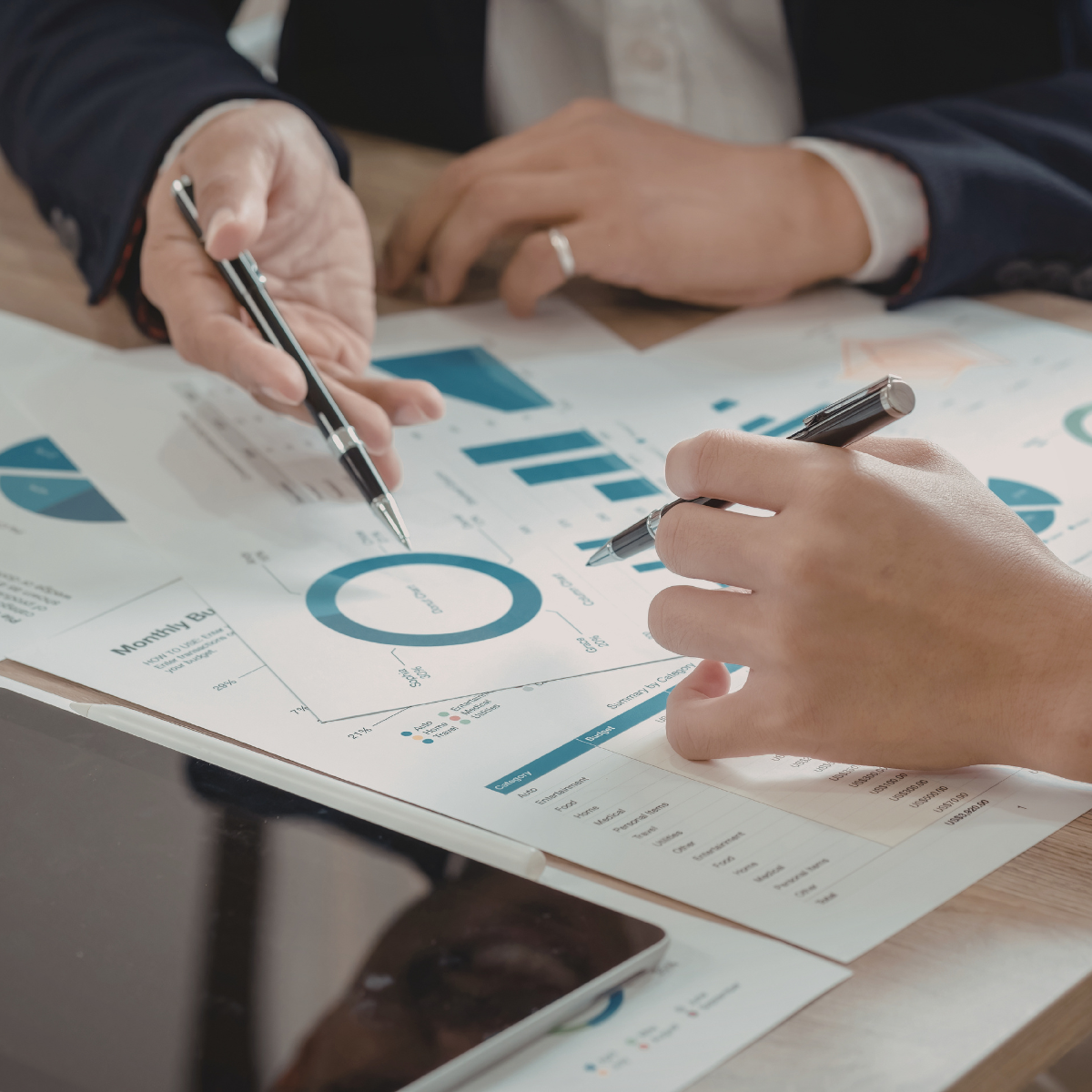 Two professionals reviewing sustainability reporting charts and documents in an office