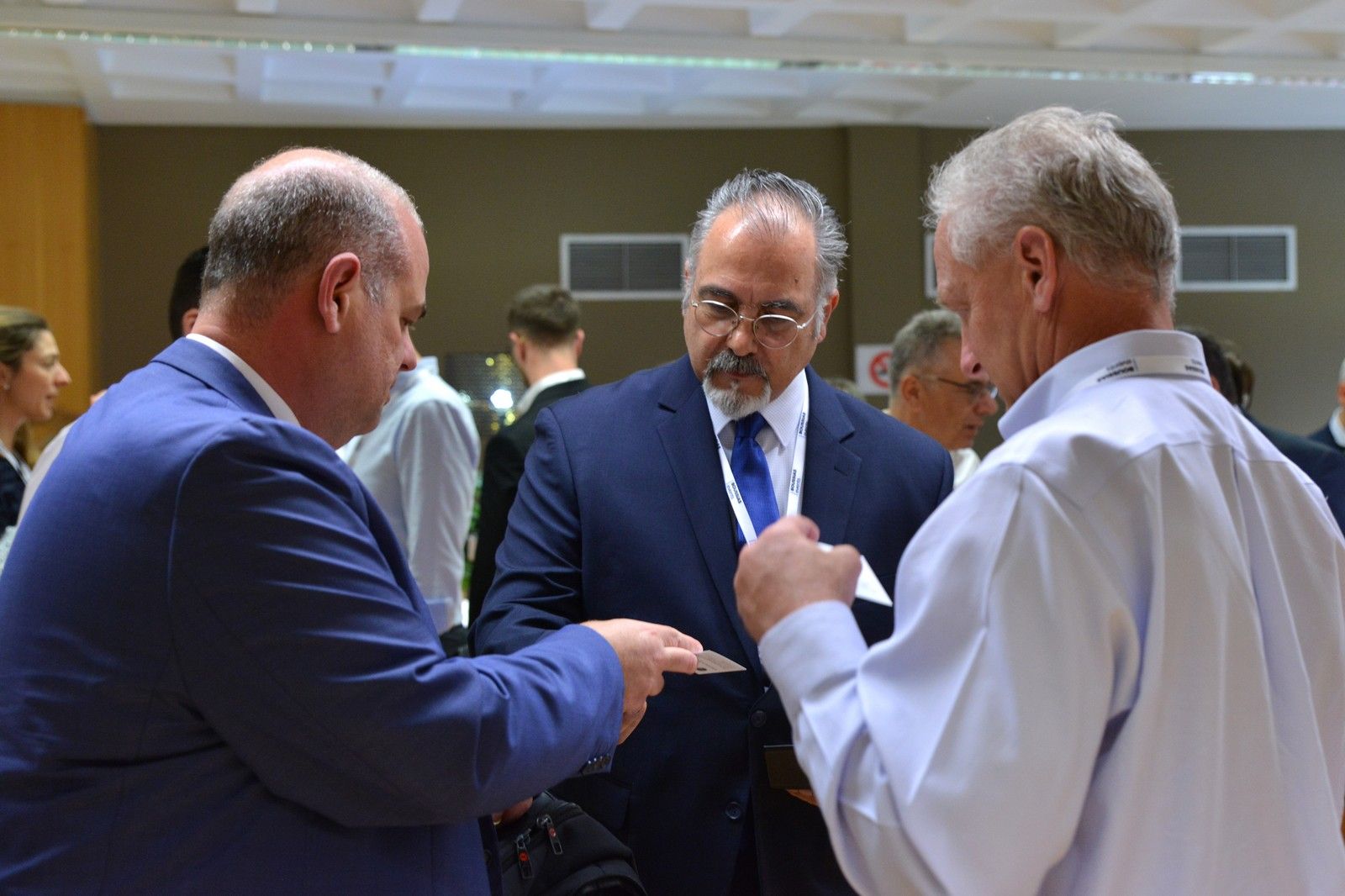 Kon talking with two other business men at conference