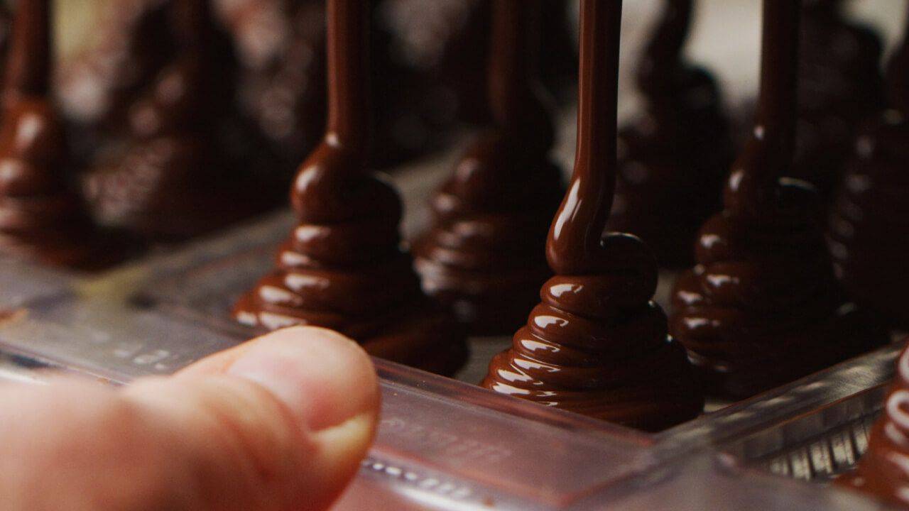 image of chocolate pouring into chocolate molds
