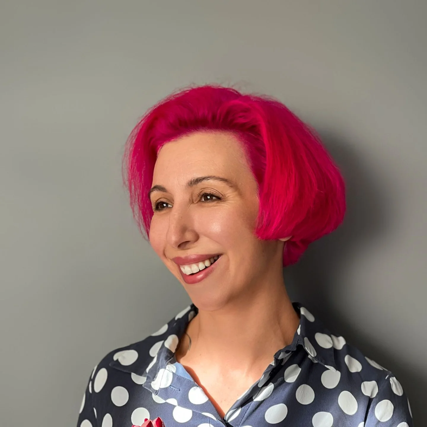 Image of Tiga-Rose Nercessian smiling while standing next to white orchids