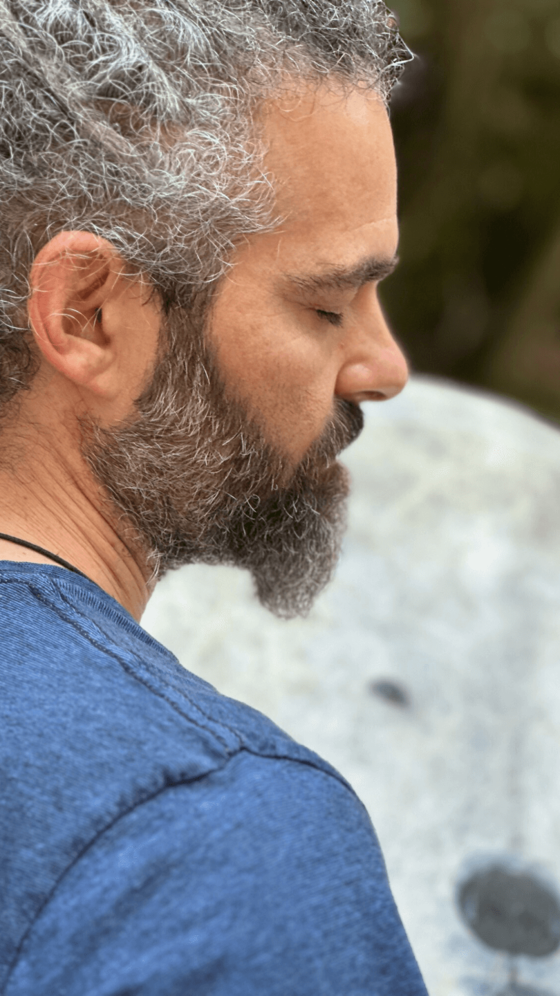 man playing a drum with closed eyes exampling the sacred masculine
