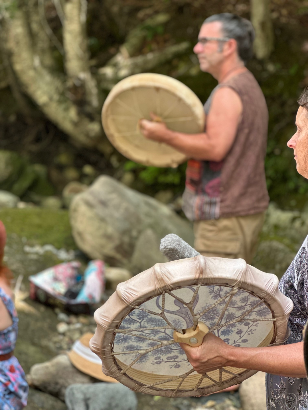a woman and a man playing a drum in sacred union