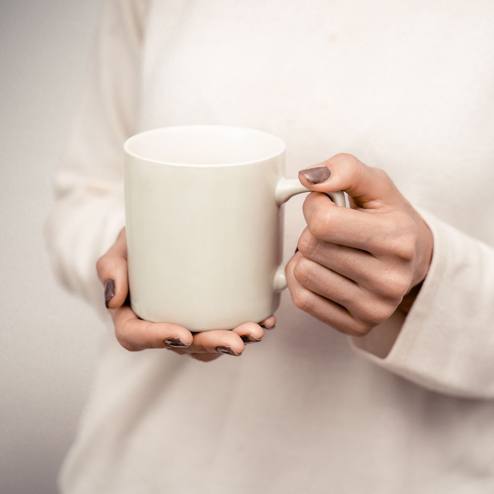 Minimal neutral woman's hand holding mug