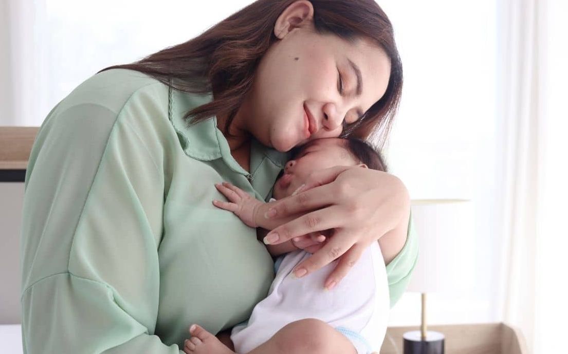 Mother embracing her baby after a successful feeding session using Reflexive™ Latching techniques from the masterclass.