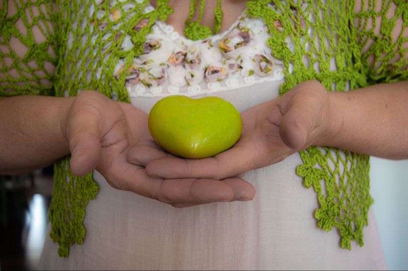 Woman holden a green heart stone in her hands.