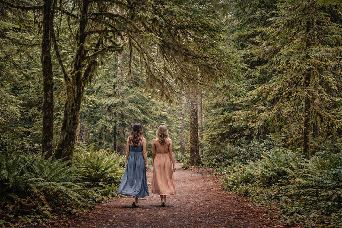 Two women wlaking along a forest track.