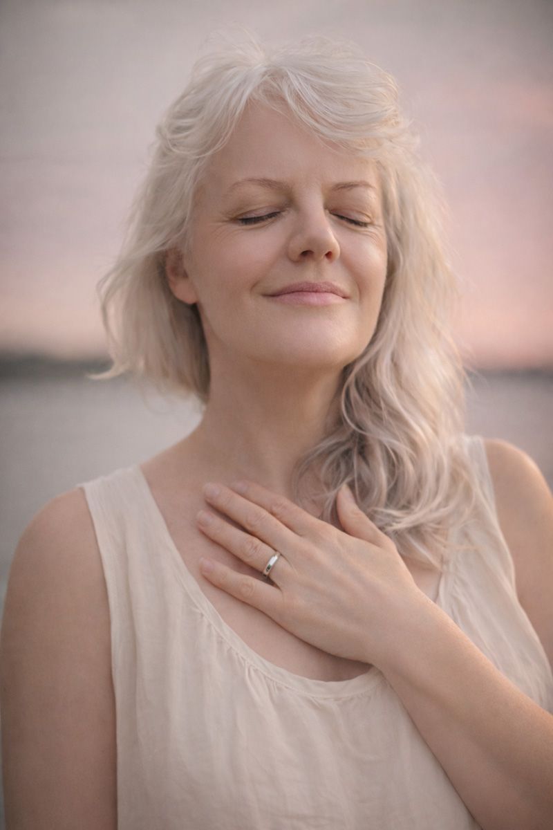 Deborah Christensen with closed eyes and hand on heart.