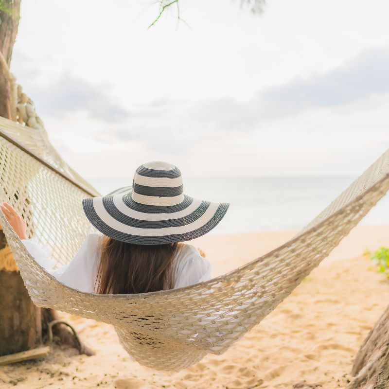 happy couple in love holding one another on a beach with ocean behind them