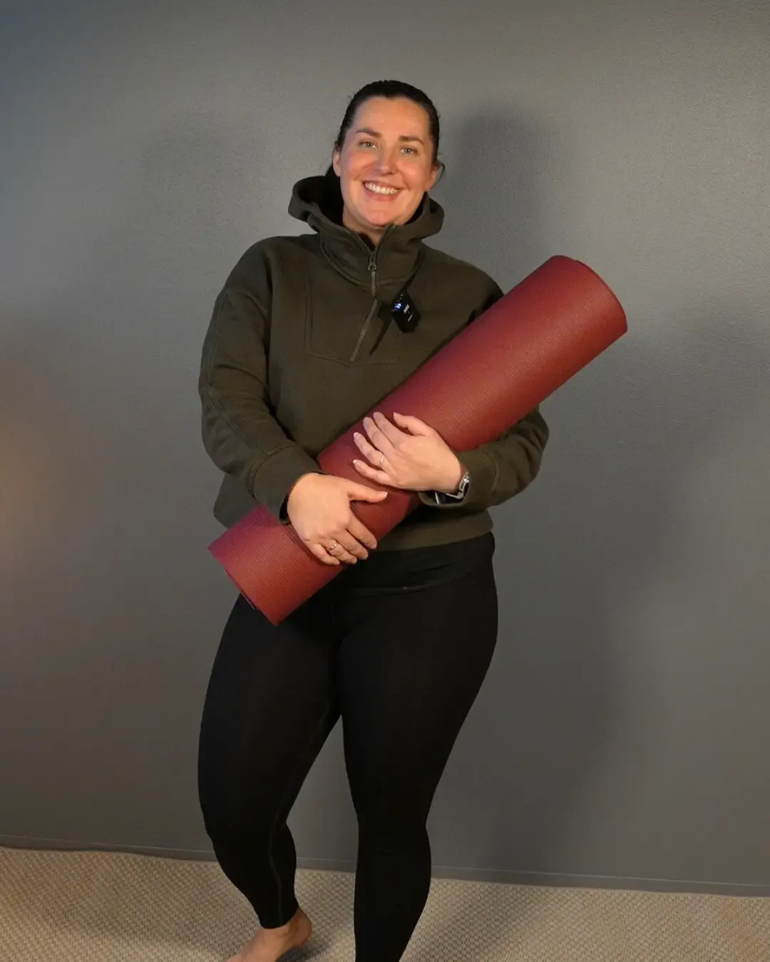 Kati Pallasvuo hymyilee joogamatto kädessä