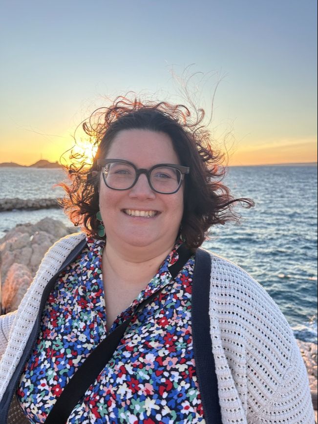 Sarah Nolasco neuroinclusive coach. Smiling with a sunset behind me