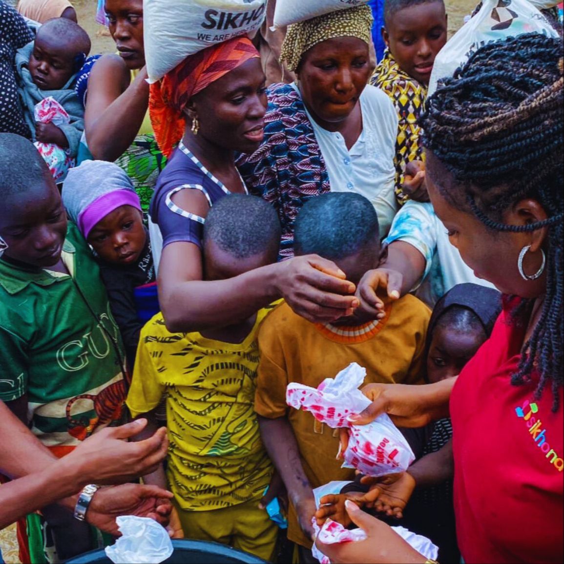 Volunteers handing out food packages to people during a community feeding event.