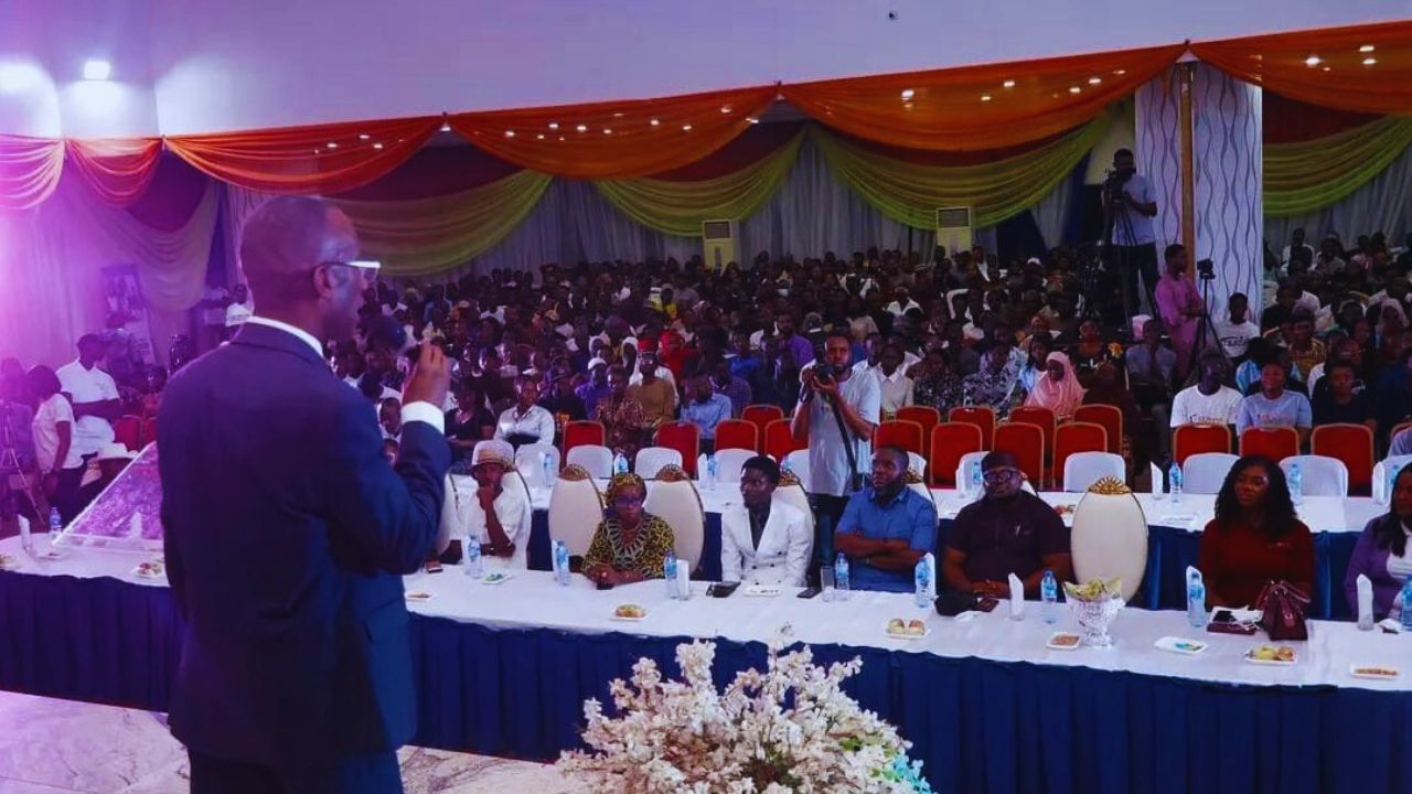 Dr. Michael Thompson standing at the front of a conference room, speaking to an audience.