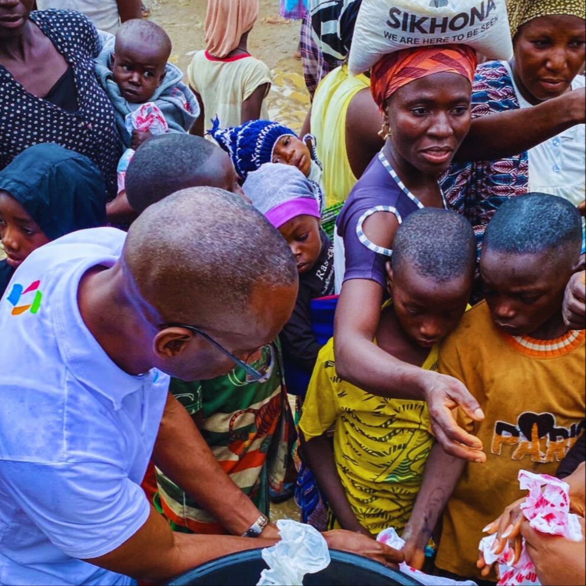 Children being served food by Dr. Michael Thompson and volunteers.