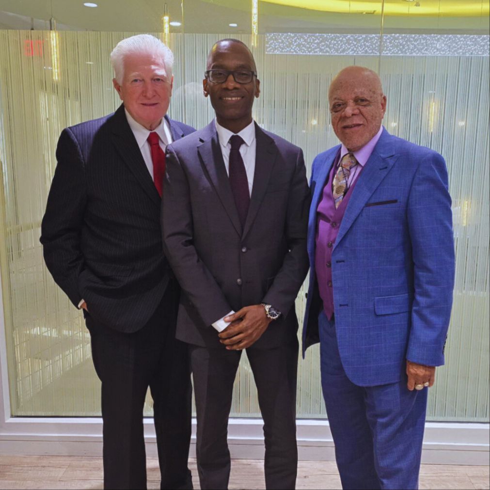 Dr. Michael Thompson standing with two men, posing for a photo.