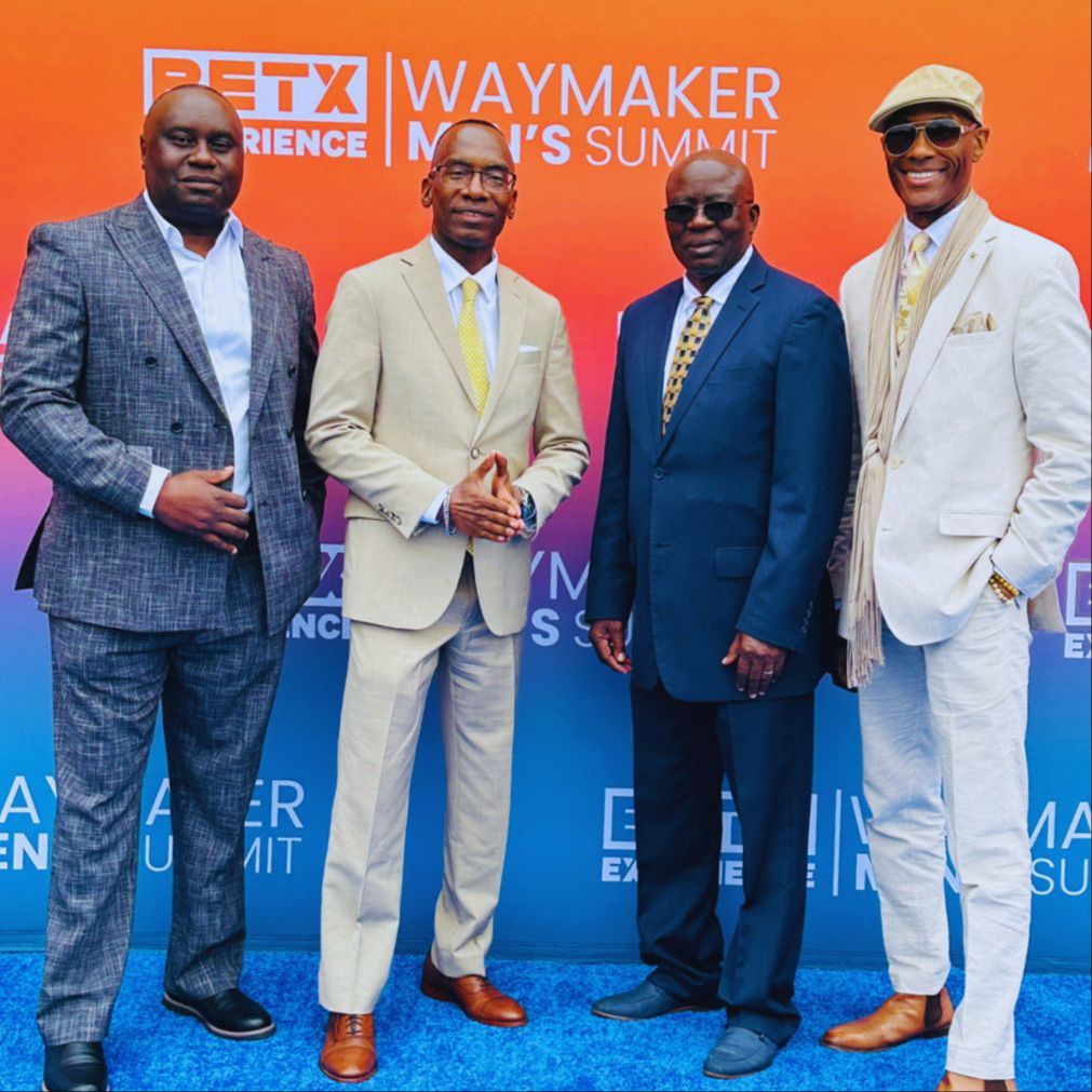 Dr. Michael Thompson and three other people standing in front of a Waymaker Men’s Summit sign