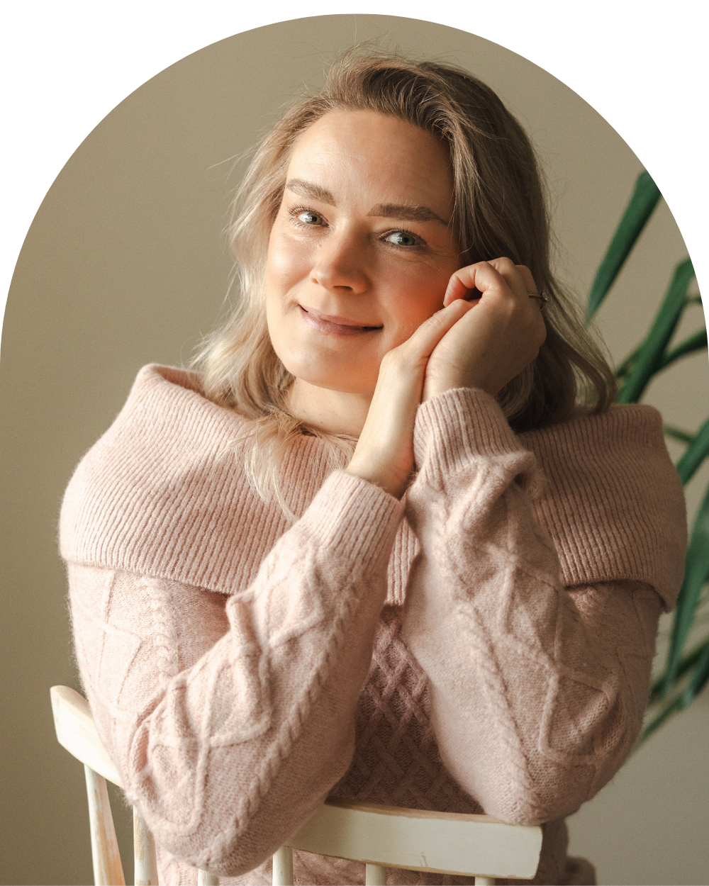 psyykkisen ja kokonaisvaltaisen hyvinvoinnin verkkokurssivalmentaja naisille hymyilee istuen tuolilla