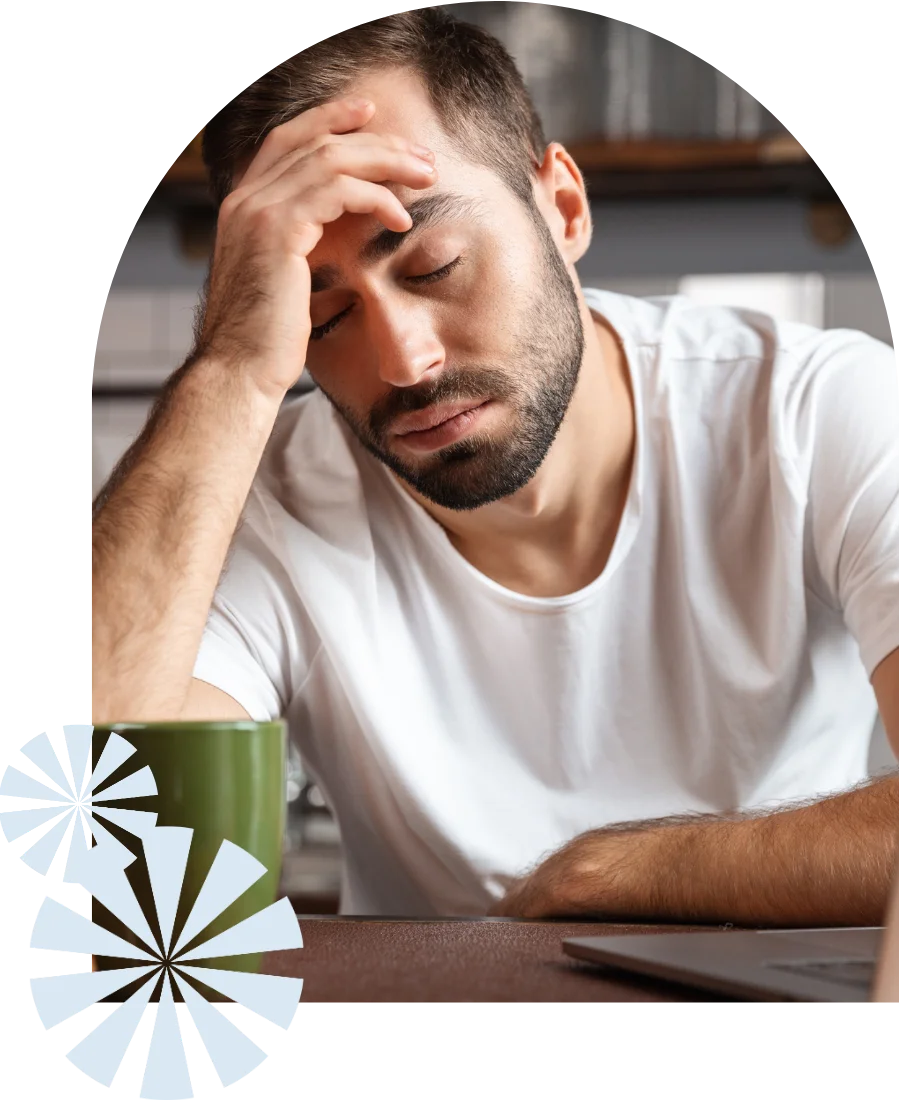 väsynyt ja univaikeuksista kärsivä mies puoliunessa työpisteellä