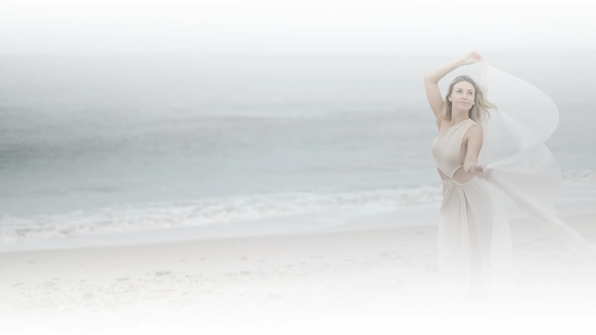Nikoleta on a beach with a veil in the wind
